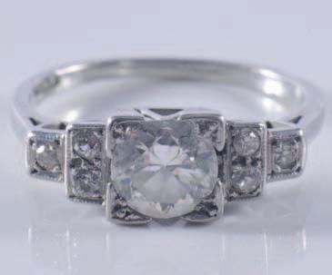 An 18ct white gold and diamond mounted threestone ring with central circular brilliant-cut stone