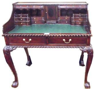 mahogany desk fitted with numerous drawers, press, secret drawers, two frieze drawers with brass drop handles, on carved cabriole legs with claw on ball feet 500-800