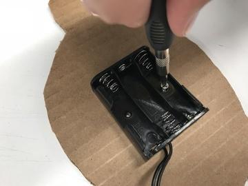 Use screwdriver to poke holes in the cardboard.