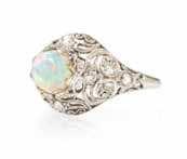618* An Edwardian Platinum, Opal and Diamond Ring, in an openwork setting with millegrain edging, containing one round cabochon cut opal measuring approximately 6.