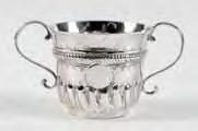 132 133 134 132 A George I porringer with twin scroll handles, the body with spiral fluted and reeded decoration, having a gadrooned girdle and circular