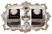 150-250 133 A Victorian desk inkstand of rectangular outline with foliate scroll border with pierced panels, the central taper stick with snuffer, flanked by