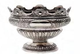 149 150 149 A late Victorian circular pedestal punch bowl with shaped undulating rim, the upper part embossed with flowers and scrolling foliage, the lower part with alternating reed and