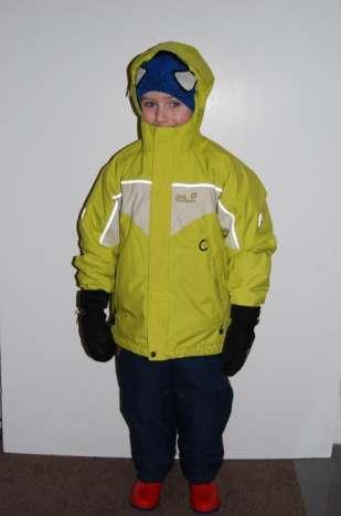 The same child now has a waterproof coat on, water resistant mittens and a woolly hat.