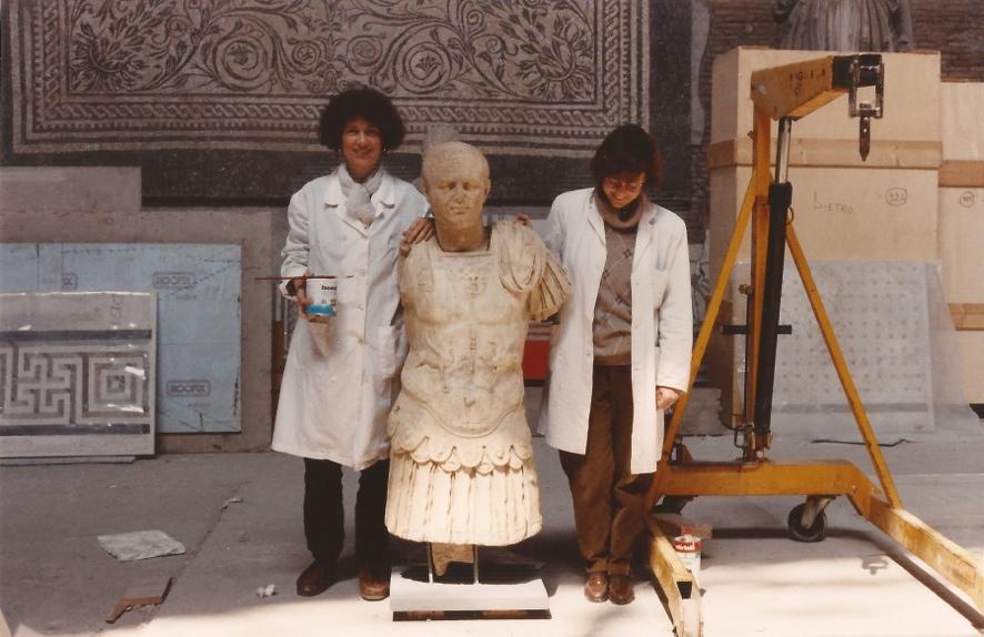 After mounting his head on his armour-clad body, museum staff Simonetta Riccio (left) and Emanuela Franco pose with the newly restored marble sculpture of a Roman centurion That armor is what makes