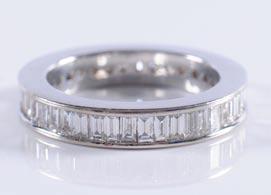 A baguette-cut diamond eternity ring channel-set with baguette-cut stones estimated to weigh a total of 2.0cts, size O. 1200-1400 316.