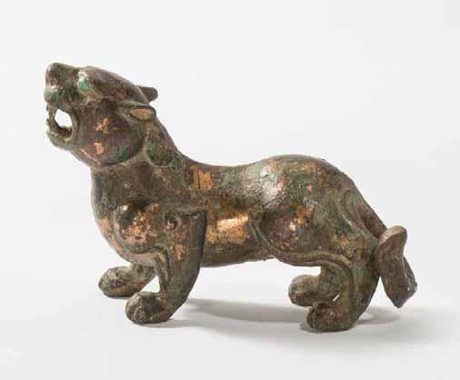 39 18 18 Late Warring States or early Western Han Dynasty (250 BC-200 BC) high, with open mouth showing its teeth, his eyes inlaid with turquoise, the sculpture with remains of gilding. L. 12.5 cm R.