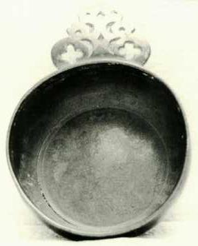 Item 466 A bulbous sided one eared porringer fixed to the side by a V.