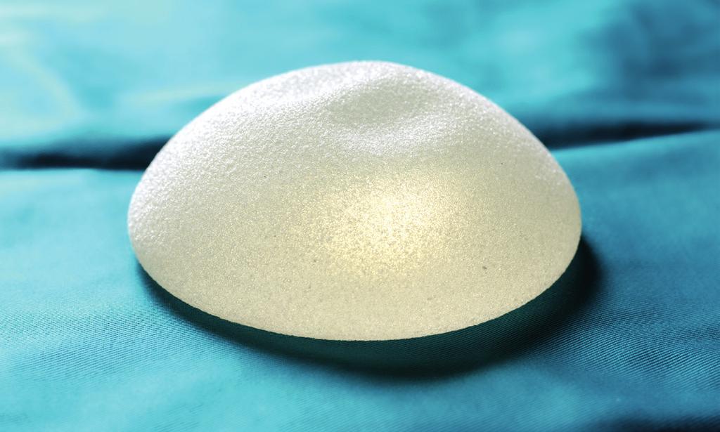 Textured breast implants Textured breast implants develop scar tissue to stick to the implant, making them less likely to move around inside of the breast and become repositioned.