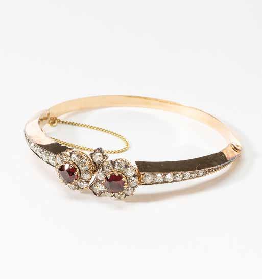 48 A 14 carat gold, diamond and garnet bangle Circa 1900 At the wrist centered by two clusters, each centered by a cushion-cut garnet, within old-cut diamond surround, the bangle