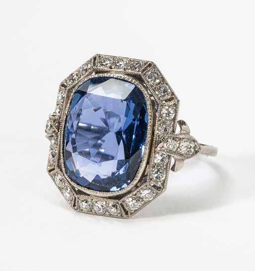 61 A platinum, diamond and blue sapphire cluster ring 20th century The ring centered by a cushion-cut sapphire within old-cut diamond border, the band with foliate-shaped diamond set motif, the mount