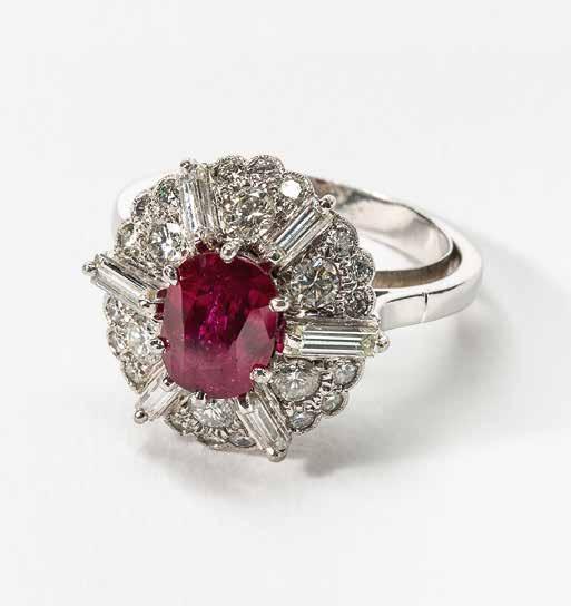66 A 14 carat white gold, diamond and ruby cluster ring Circa 1970 Centered by an oval-cut ruby (not tested), flanked by step- and circular-cut diamonds Total