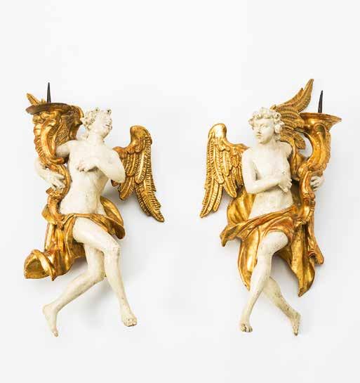 175 A pair of German Rococo polychrome giltwood winged angel candles Circa 1770 Each supporting a pricket candle holder in opposing arms, a sash