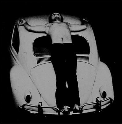 Trans-fixed. Chris Burden. Performance, Venice CA. April 23,1973. Burden said of this performance, "Inside a small garage on Speedway Avenue, I stood on the rear bumper of a Volkswagen.