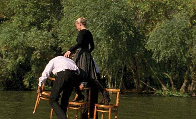 WALK OF THREE CHAIRS / HOD TRI STOLICE, 2003 Hod tri stolice prikazuje Bredu Beban na plutajućem splavu postavljenom između dve obale Dunava u Beogradu, na mestu za koje mnogi veruju da predstavlja