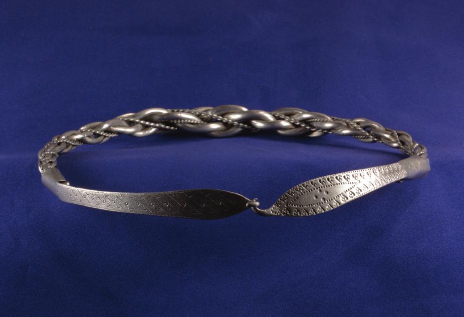cone. The smaller neck ring (Fig. 4) has a thin silver wire together with a linen cord wound four times around one end of the plait, probably to fix the loosened attachment.