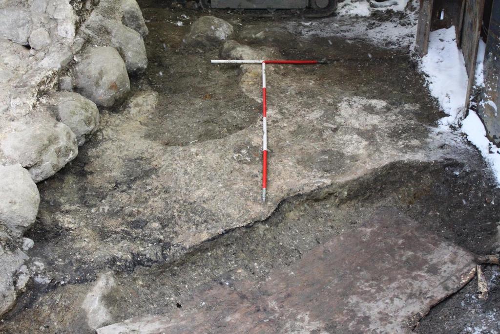 Fig. 111. Part of foundation layer (SD34228) north of the foundation wall, facing west. In front truncation by a 19 th century wooden water pipe not yet exposed. Photo: Museum of Copenhagen.