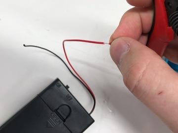 Remove batteries before hacking on your battery pack! Snip the JST connector off your battery pack. We won't be needing this. Strip about 1/4" insulation off the end of the red and black wires.