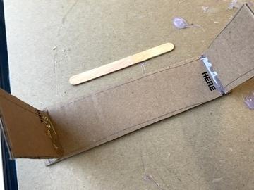 Make a line of hot glue along one outside edge of the cardboard.