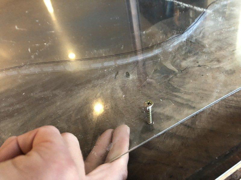 I used 2" wood screws to secure the acrylic sheet to the bottom of my table. I carefully drilled four holes in the acrylic, outside the "river" area. Acrylic cracks really easily!