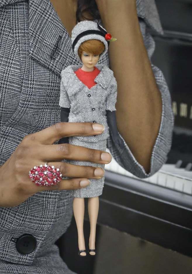 8 of 10 In this Nov. 5, 2018 photo, model Tiffany Hendrix holds a Barbie doll while wearing a matching outfit by designer Katie Echeverry in New York.