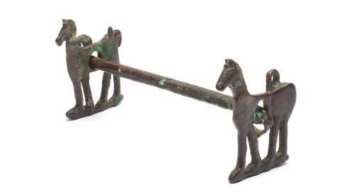 79 79 A RARE PERSIAN BRONZE HORSE BIT, FIRST MILLENIUM BC comprising a pair of pierced side panels formed as stylised horses, each fitted with a pair of loops at the top (one loop missing), and with