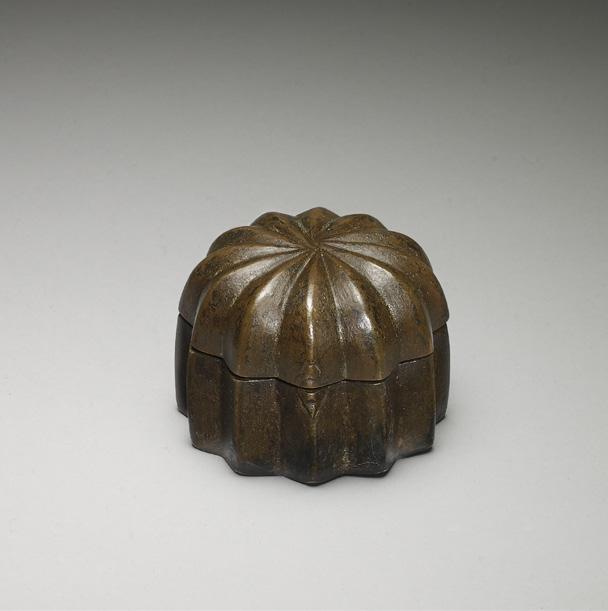 22 Bronze pandan box Rajasthan, India, 17th 18th century Height: 5 cm (2 in) Diameter: 7 cm (2¾ in) This circular cast bronze container, or pandan, was used to store pan, or betel quid, after it had