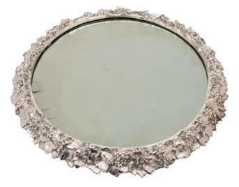 * 200-300 159 A silver plated surtout-de-table of circular form the mirror plate enclosed by a vine leaf and grape decorated border, raised on