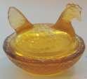 MAKER UNKNOWN HEN ON NEST OPEN SALT. STRAIGHT HEAD, SCALLOPED EDGE ON CROSS HATCHED BASKET. AMBER. SMITH GLASS CIRCA 1970 CA007 CA038 $11.