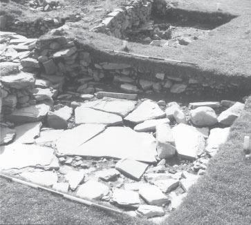 27 Fig. 14 - Entrance paving of building K3 from N.W. The ranging poles show feet. level here and thus the association of this hearth with structure K3 uncertain.