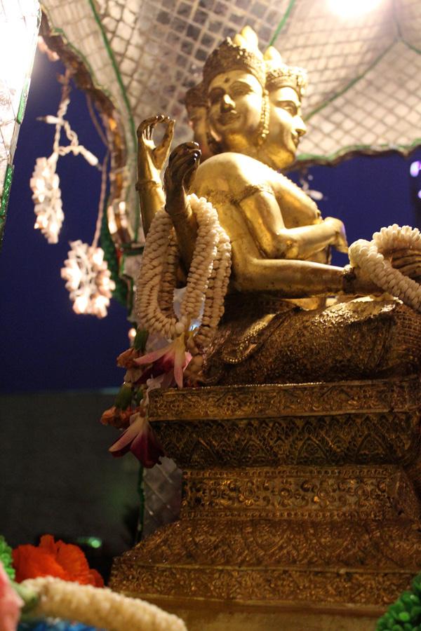 Colorful plastic garlands adorn it. Its mosaic pieces glitter at night and a small light illuminates a small gold statue.