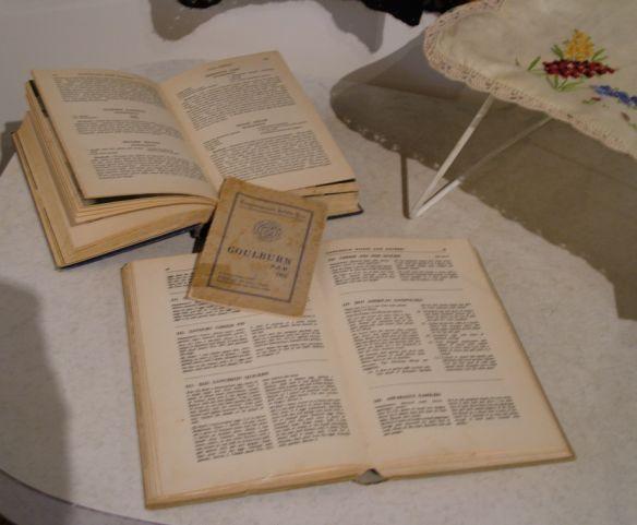 Above are recipe books and a glimpse of an embroidered