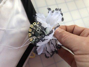 Sew the bottom petals of the flower to the Circuit Playground, through the unused pads.