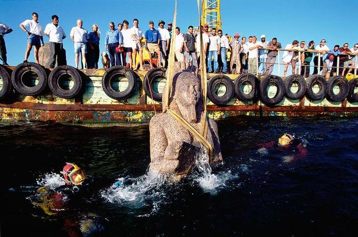 The divers and their team of researchers carefully lift the statue to the surface in