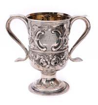 A Victorian christening mug, on a low pedestal foot, scroll handle, with embossed and engraved sprays of lilies of the valley to the sides, London 1857, maker Edward and John Barnard, 10cm high, 5.