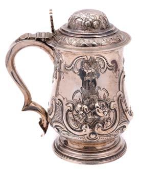 A George III baluster mug, on a stepped spreading base, with leaf capped scroll handle, later embossed and chased with floral sprays, scrollwork