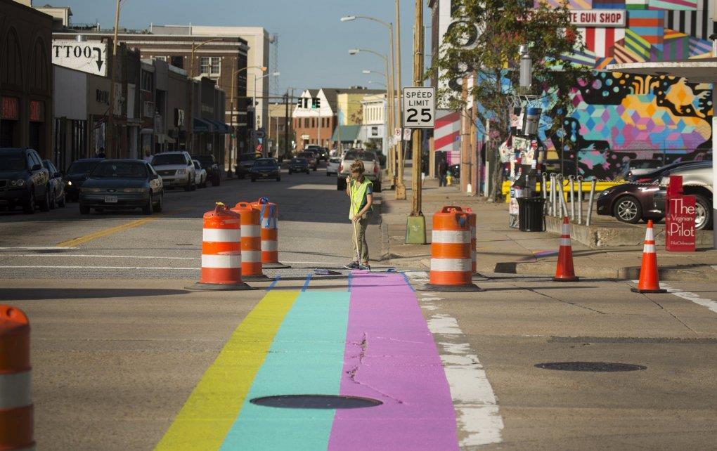 Rachel McCall paints the street at the corner of Granby Street and Brambleton Avenue, the