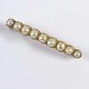 35mm, comprising pin type bar with ornate circular centre set with a small cultured pearl, tested 9ct gold & another bar