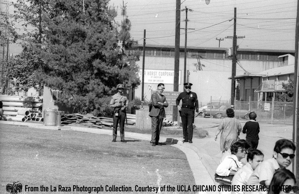 LAPD officers watch protesters demonstrating in support of Ricardo Chavez Ortiz at L.A. County Jail La Razaphotograph collection.