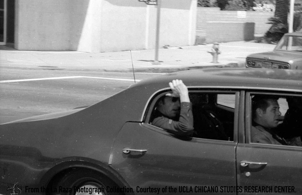 LAPD officers in car during a Vietnam protest La Raza