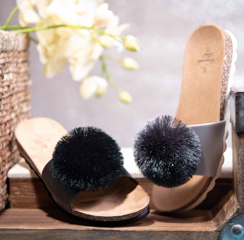 THIS SLIP-ON HAS A PLAYFUL SIDE WITH A PUFFY POM EMBELLISHMENT IN BLACK OR SILVER.