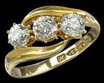 85 A THREE STONE DIAMOND CROSSOVER RING, the three old brilliant-cut diamonds claw set between crossover shoulders, mounted in 18ct gold, hallmarked for Chester, 1908, total diamond