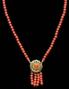 500-700 152 A CORAL BEAD NECKLACE, the uniform Corallium Rubrum beads to a piercedwork clasp/centrepiece set with central coral cabochon and