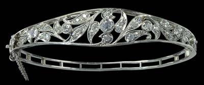 252 A DIAMOND SET HINGED BANGLE, the openwork foliate front millegrain set throughout with graduated brilliant-cut diamonds, mounted in white precious metal, unmarked,