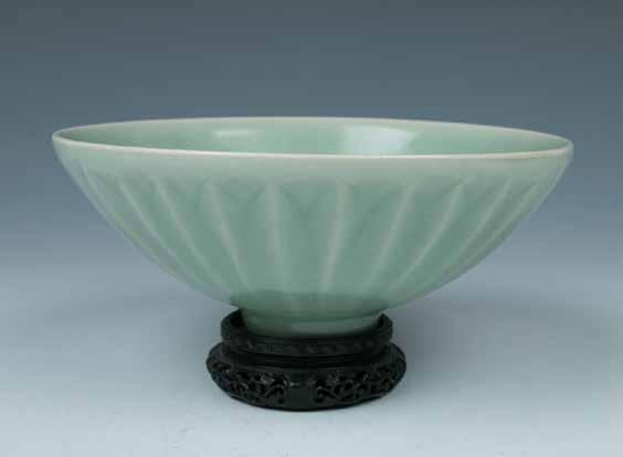 Estimate CA$3,000 - CA$5,000 155 明以前青釉小碟 CELADON GLAZE PLATE, BEFORE MING Of five petal everted form rising from a straight foot, overall celadon glazed with finely lined a strip of brown at the rim.
