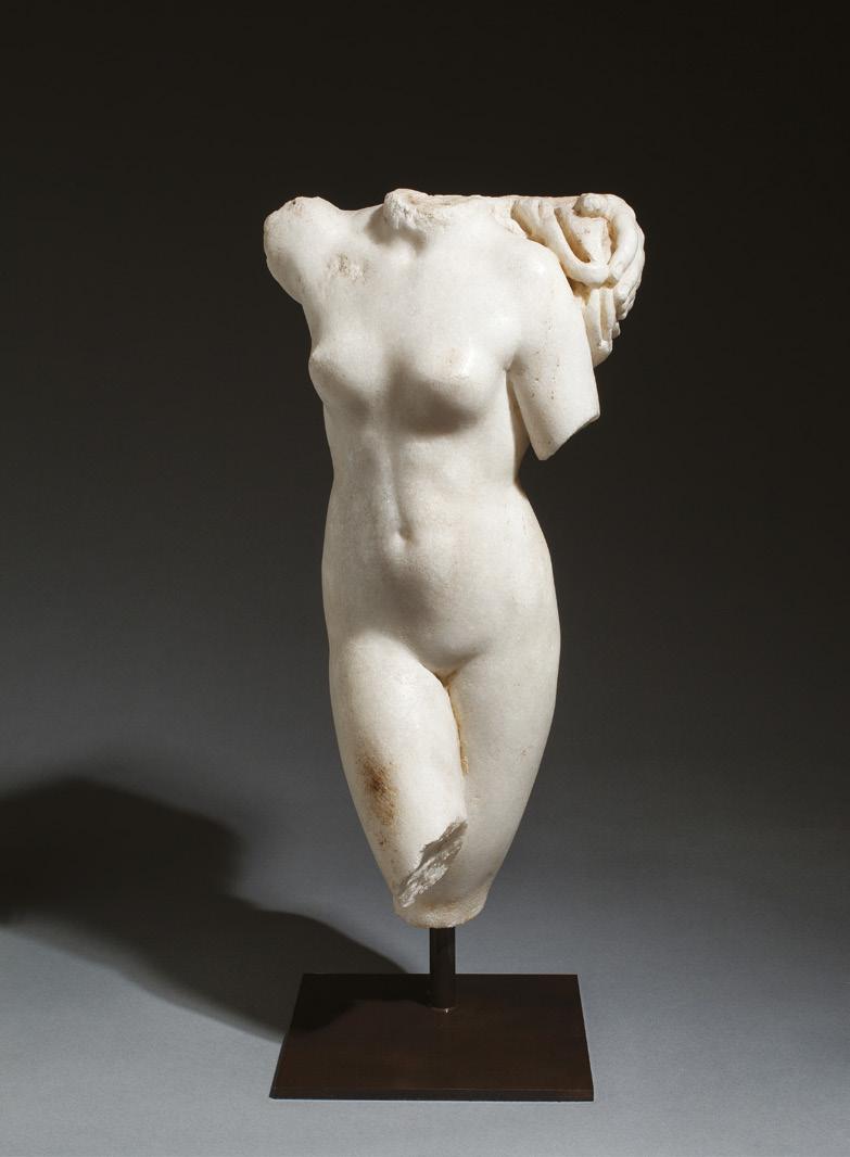 Roman torso of a nymph 2nd century AD Marble Height 39.4cm Sculpted in bright white marble, the nymph stands with legs crossed and right arm raised, exposing her youthful figure.