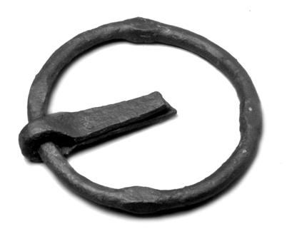 Fig. 6. A door knocker a sturdy iron ring with four knobs still inset in the iron cramp that was nailed to the door was found in one of the large postholes of the small house. 1:3. Fig. 5.