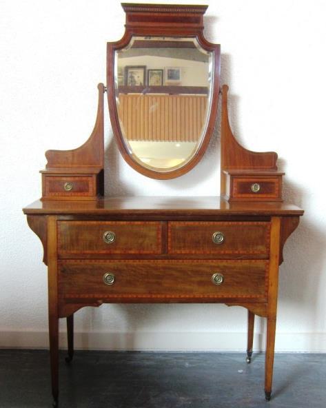 A Victorian mahogany twin pedestal Breakfront Sideboard, the raised backrest carved with scrolling leafage, the long central drawer flanked by two short drawers with cupboards