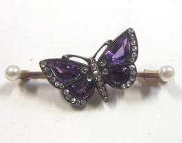 56. A pretty late Victorian/Edwardian diamond, amethyst and seed pearl Bar Brooch modelled as a Butterfly. 4 cms wide 150-200 interior band.