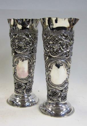 Of tapering form with crimped rim, the bodies chased and pierced with 'C' scrolls, foliage and flower heads. 25.5 cms high, 19.
